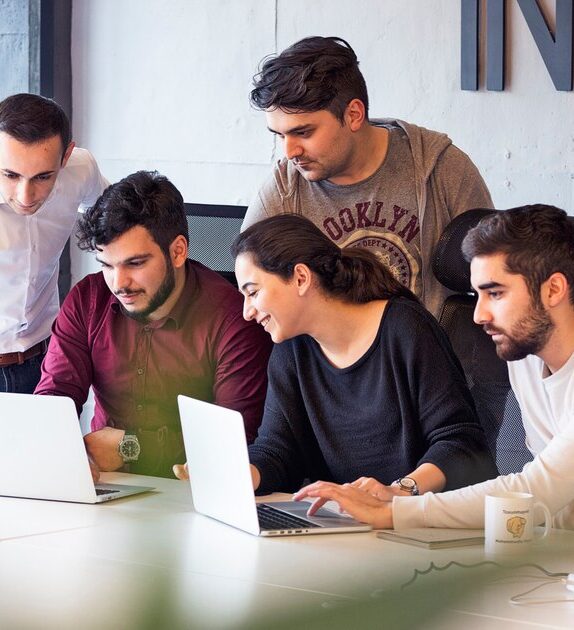 About Us colleagues working project discussing details 114579 2817 574x630 - About Us